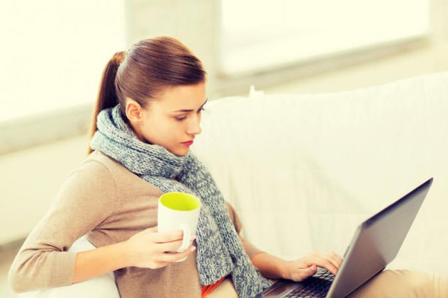 Девушка в шарфе смотрит в ноутбук
