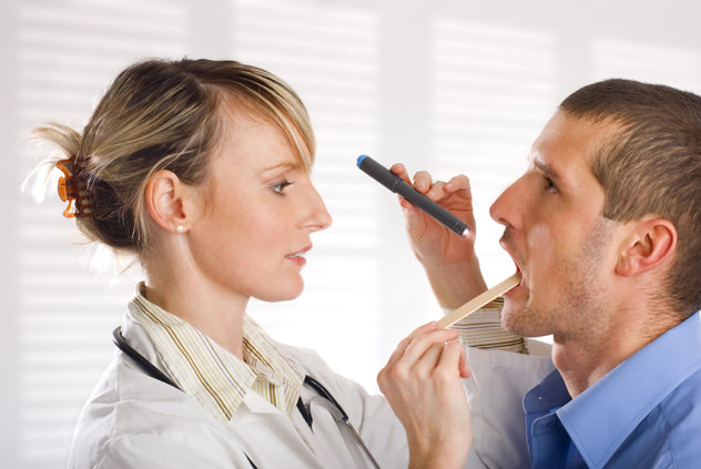 ЛОР врач осматривает горло пациенту