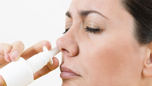 Женщина закапывает нос