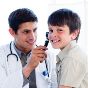 Доктор обследует ухо мальчика