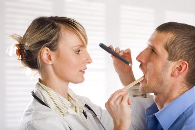 Доктор осматривает горло при лор-заболевании